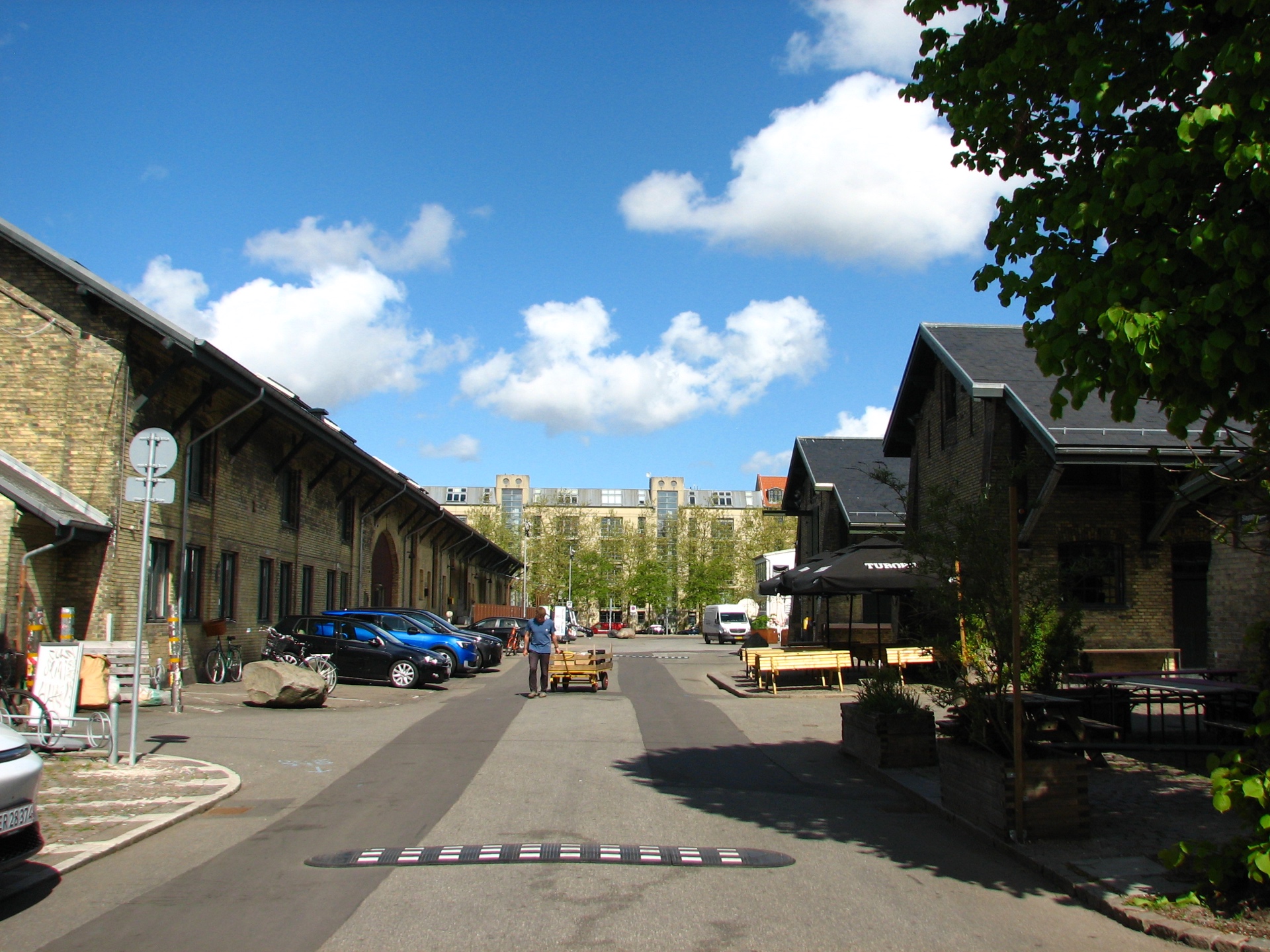 A quiet sunlit street in the Brune Kødby with the original brick market halls on either side.