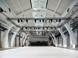Interior of Dansehallerne with arched trusses, white floor and overhead stage lighting rig