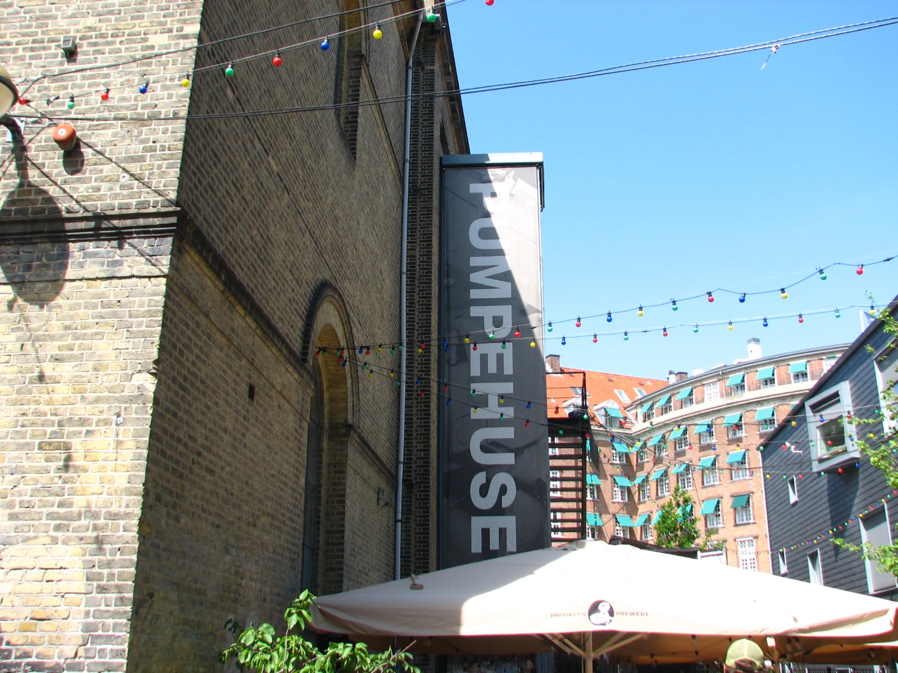 Vertical Pumpehuset sign against brick facade