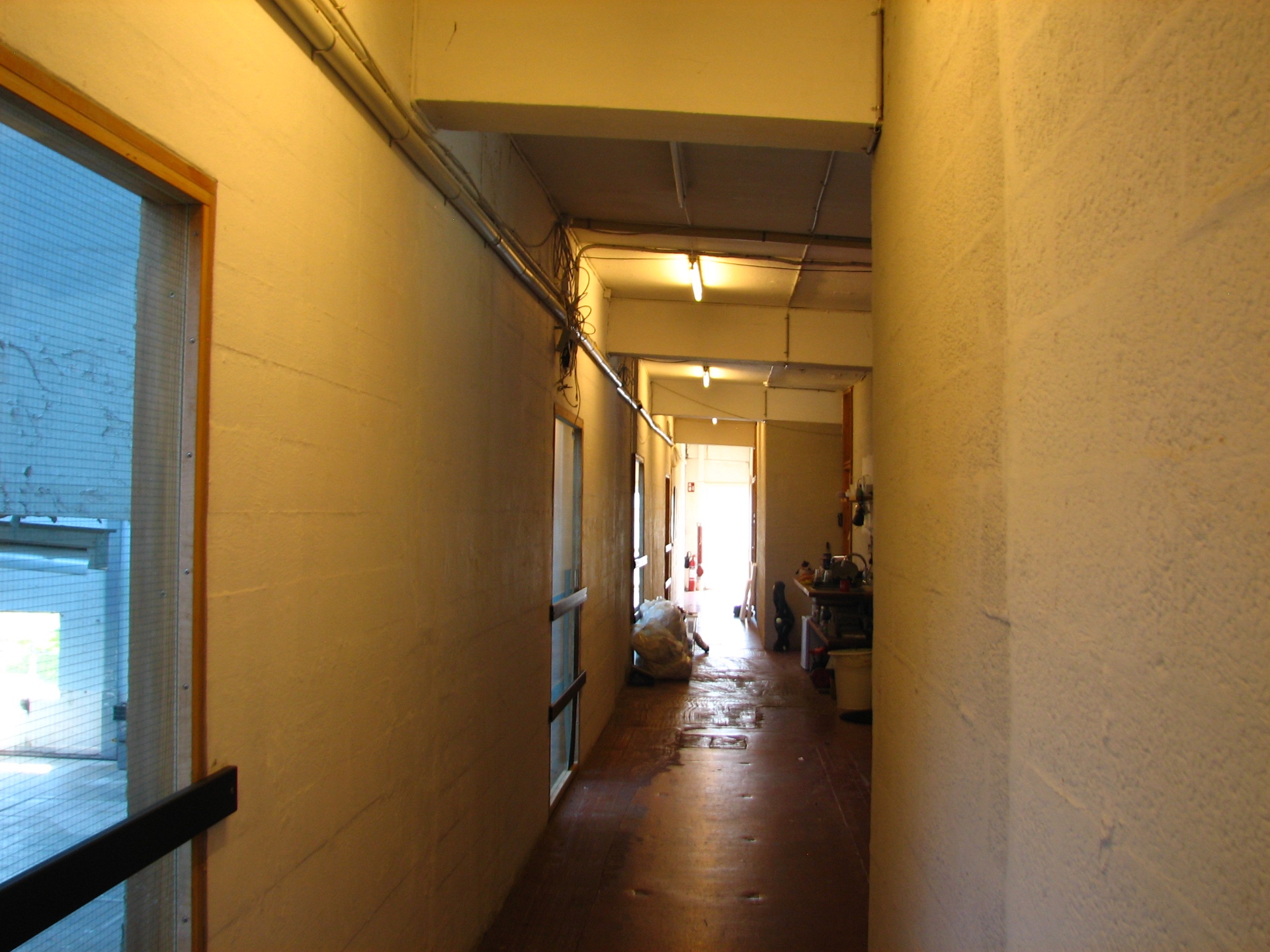 Narrow yellow corridor inside FABRIKKEN with exposed pipes